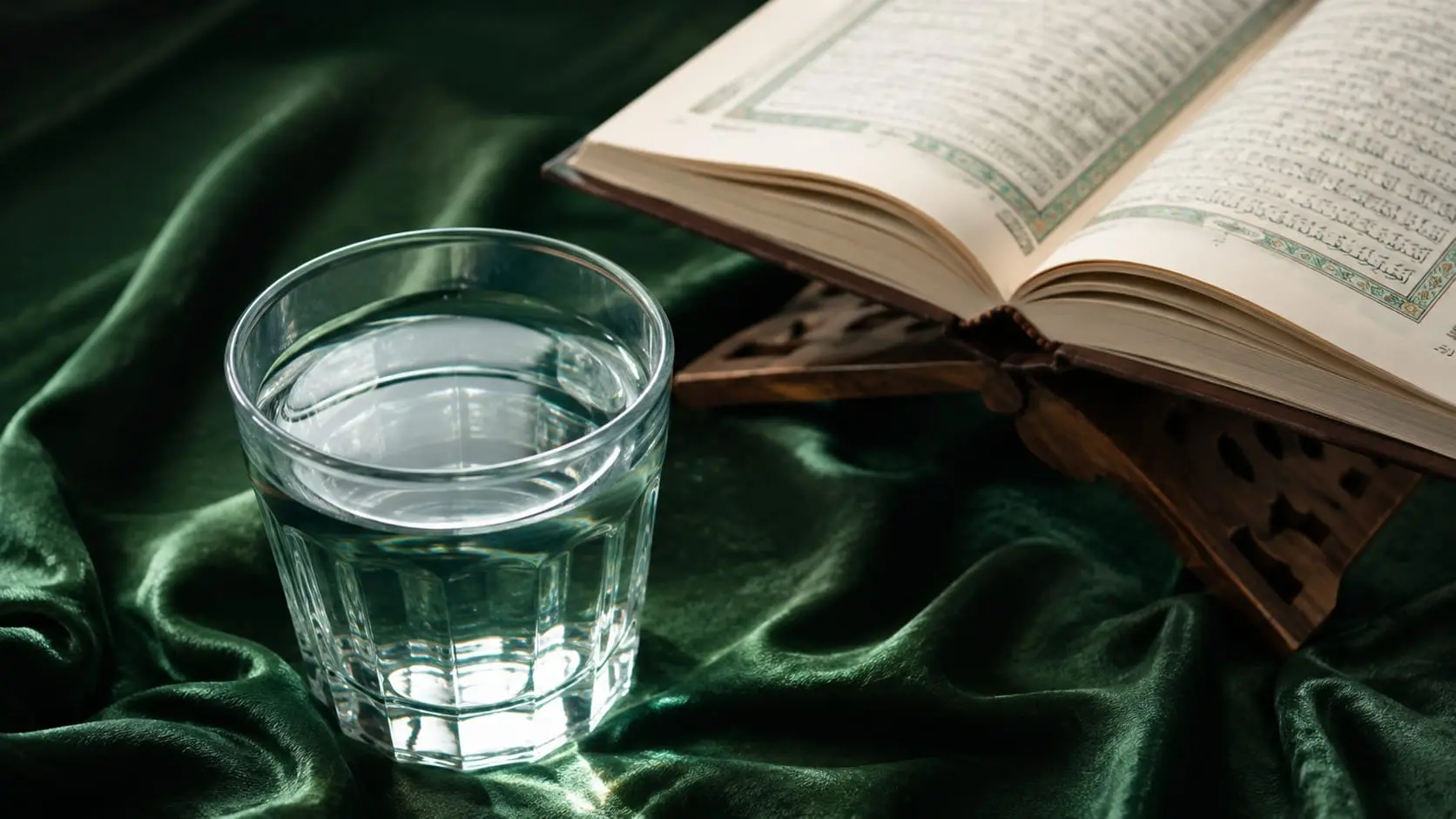 Coran ouvert sur un lutrin et verre d'eau, récitation coranique pour la roqya légiférée contre le mauvais œil