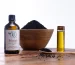 Flacon d’huile de nigelle bio Naturigelle de Naturison avec un bol de graines de nigelle et une fiole d’huile